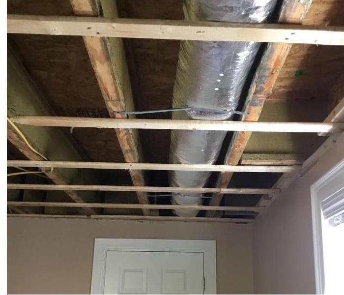 ceiling with drywall removed exposing wood framing and air duct