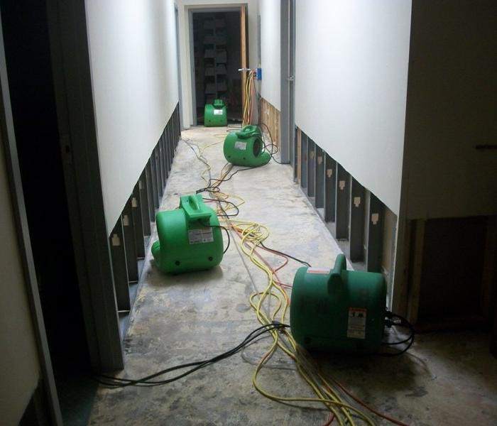 hallway with concrete floor and fans setup on the floor