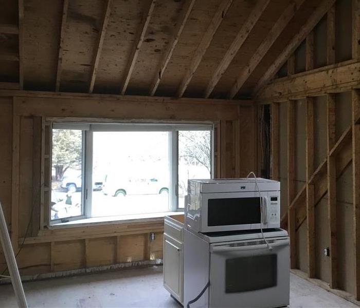 kitchen with all drywall and flooring removed to expose framing and a concrete floor