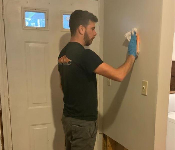 Photo of a technician cleaning soot residue from the wall